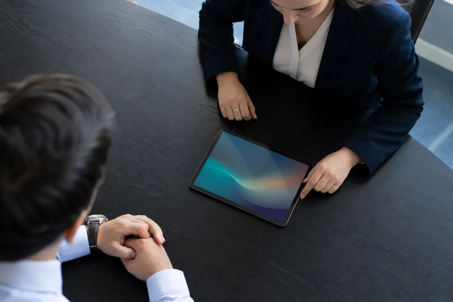 A tablet lying flat at the edge of a meeting table