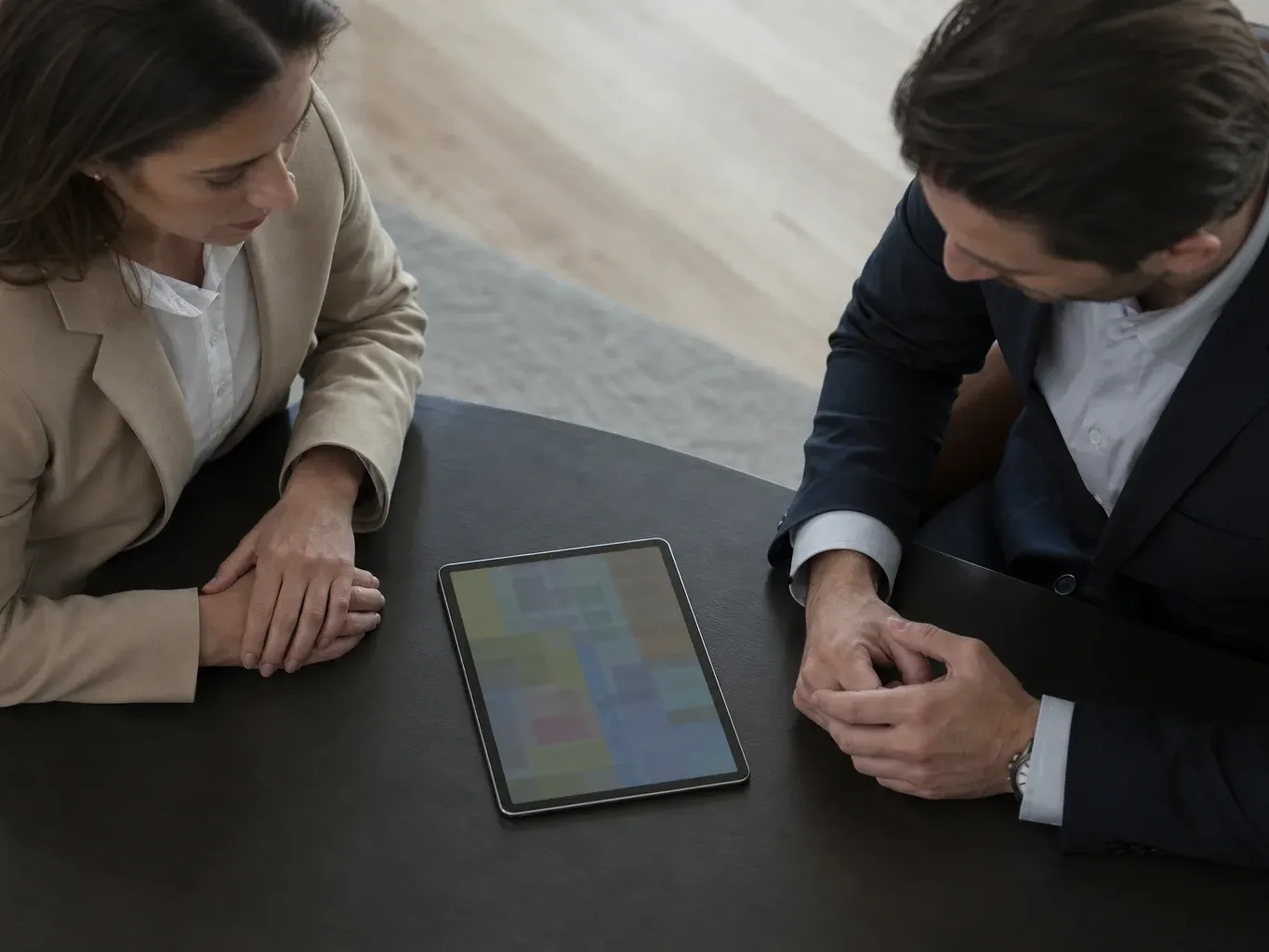 A tablet lying flat at the edge of a meeting table