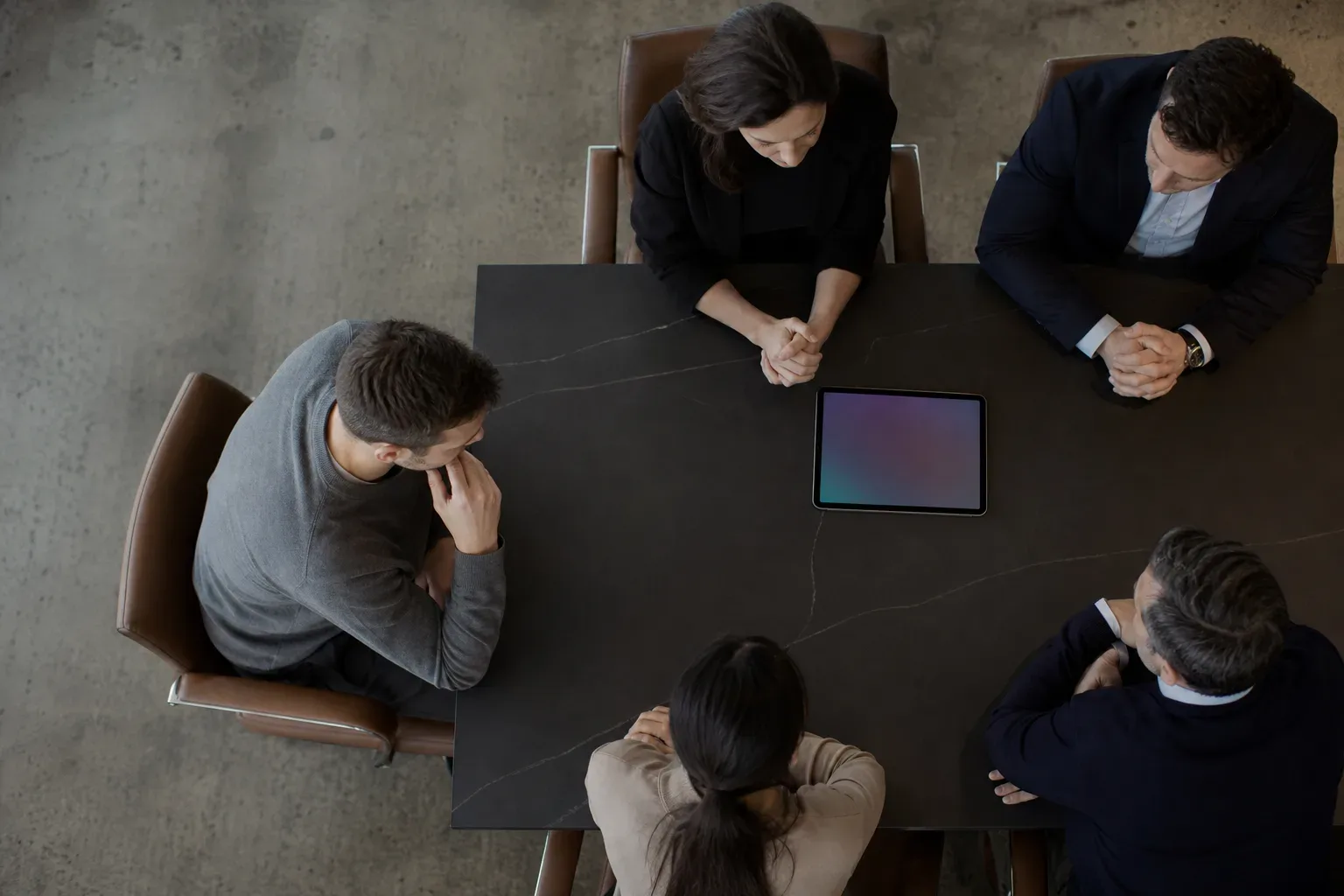 A tablet lying flat at the edge of a meeting table