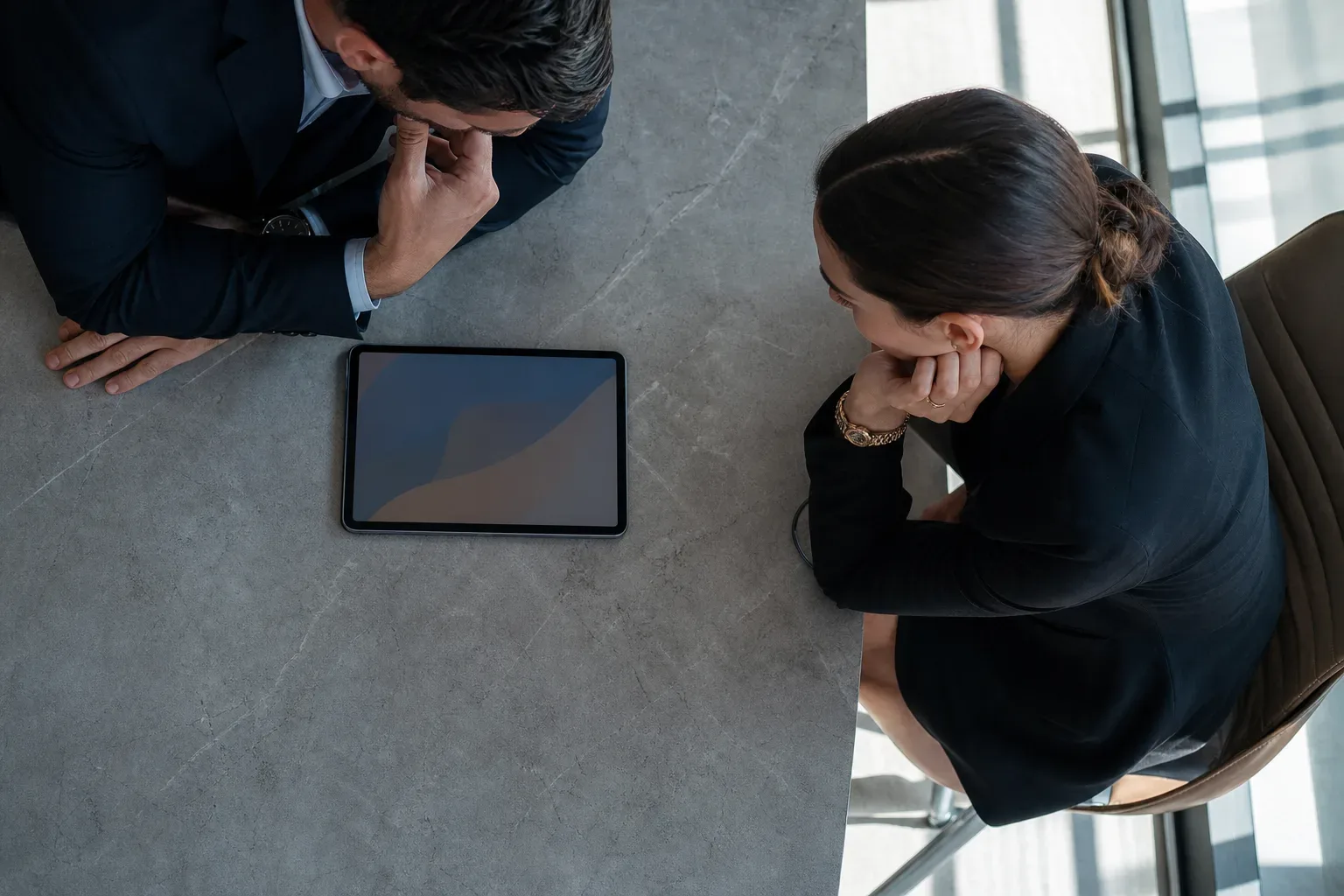 A tablet lying flat at the edge of a meeting table