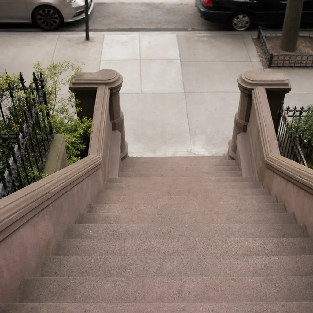 The wide stone entry steps of a classic Brooklyn rowhouse seen from street level