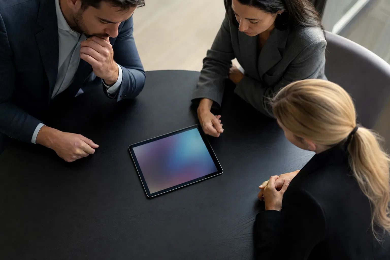 A tablet lying flat at the edge of a meeting table